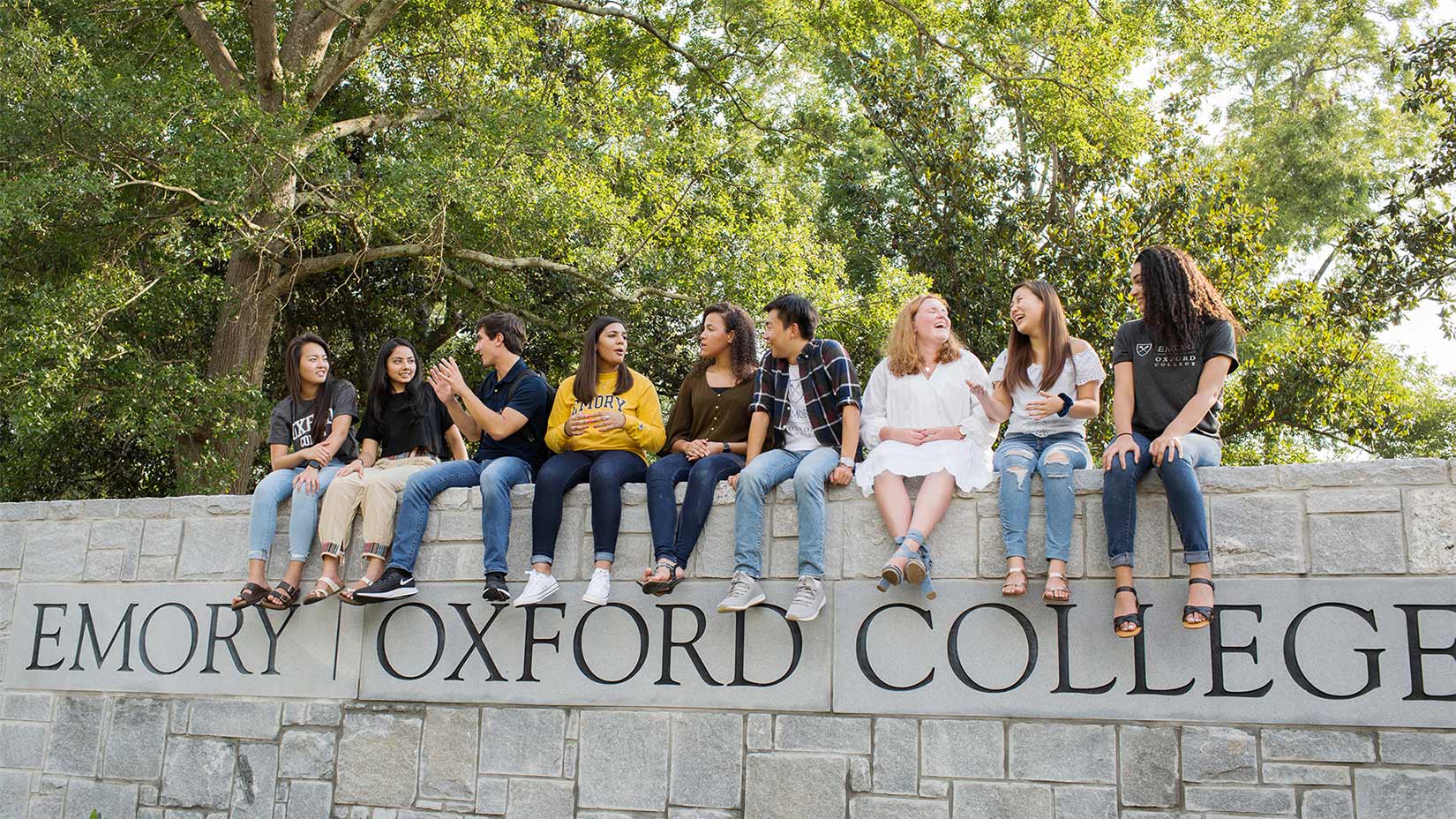 Students sit on the wall of the Oxford's main entrance.
