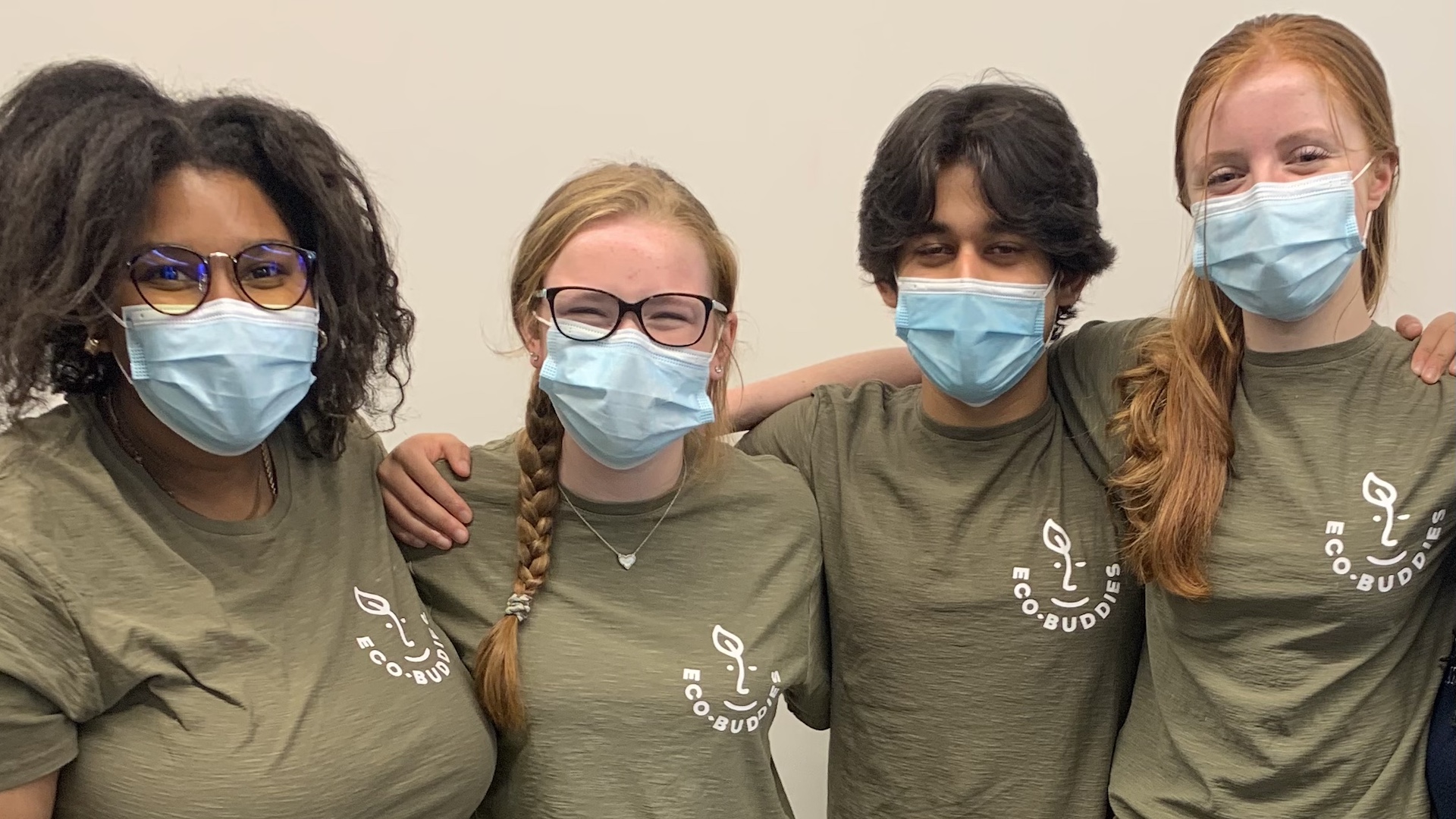 Photo: 4 students pose in Eco-Buddies tee-shirts