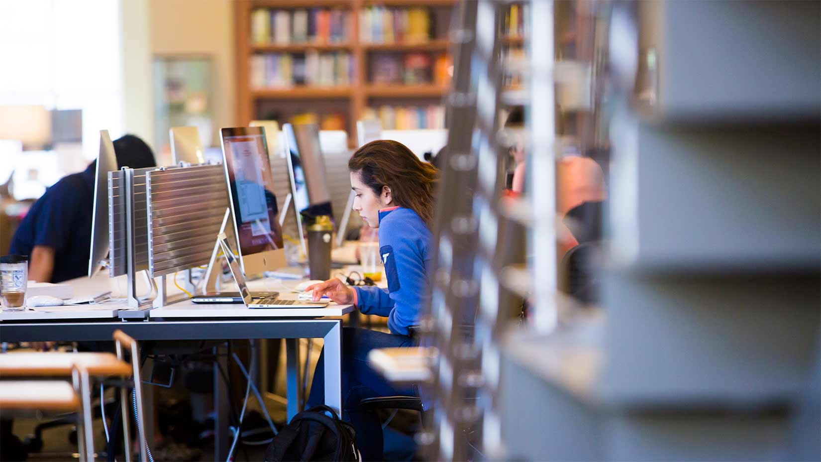 A student uses the Mac desktops in the library.