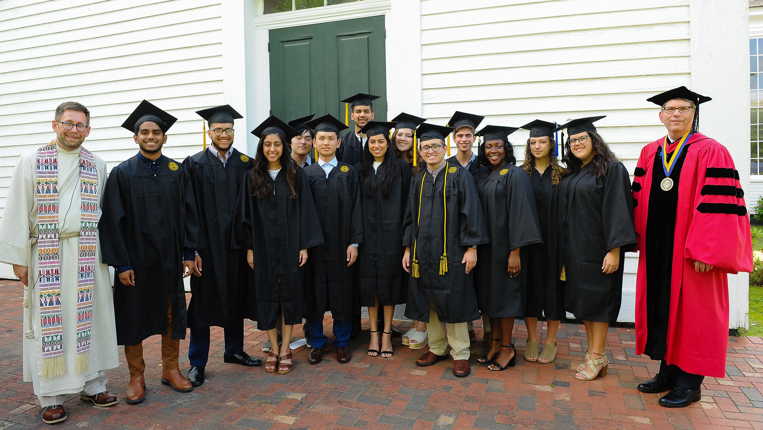 Chaplain Lyn Pace and Dean Douglas Hicks pose with graduates after baccalaureate.