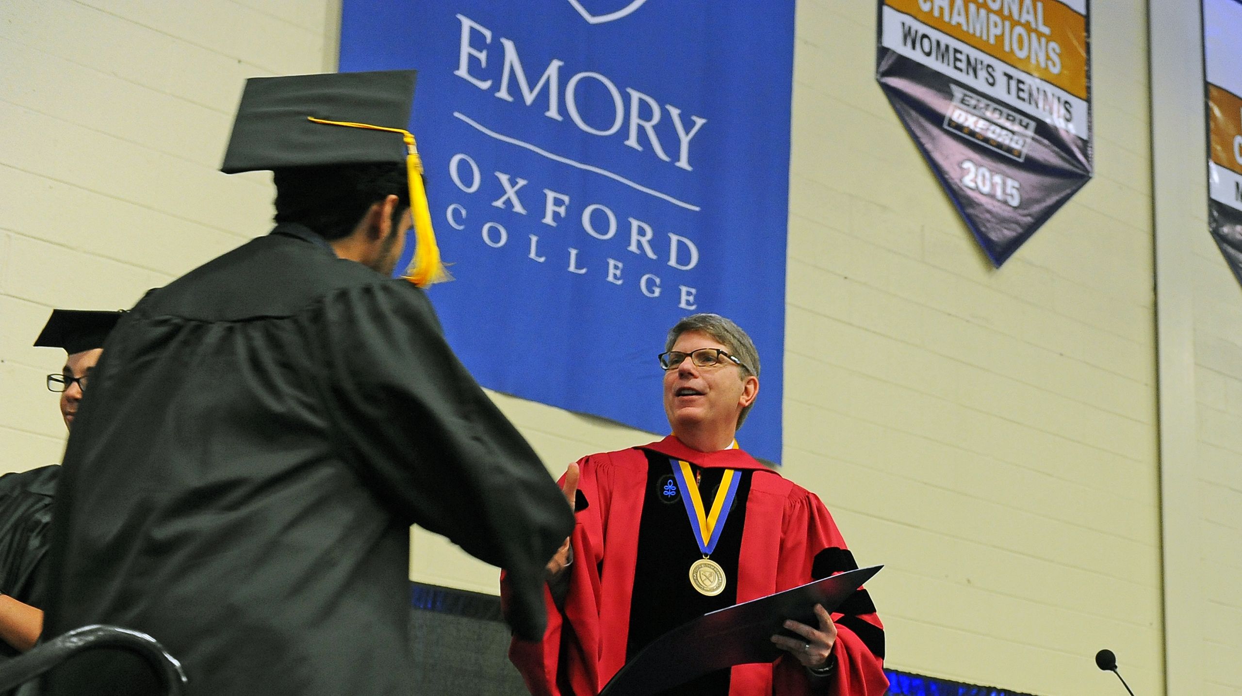Dean Douglas Hicks congratulates an Oxford graduate. 