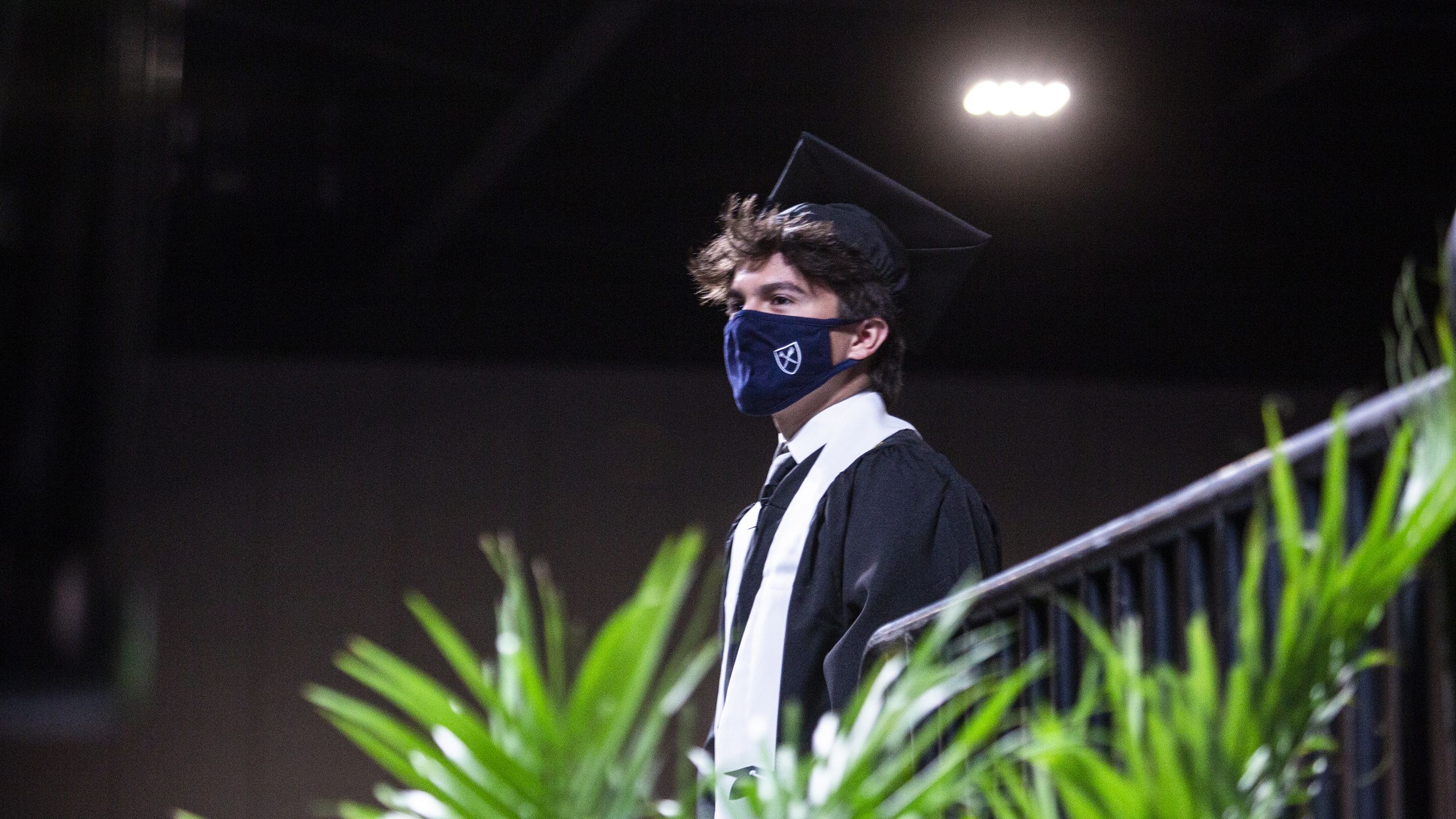 A graduate waits on the Commencement stage.