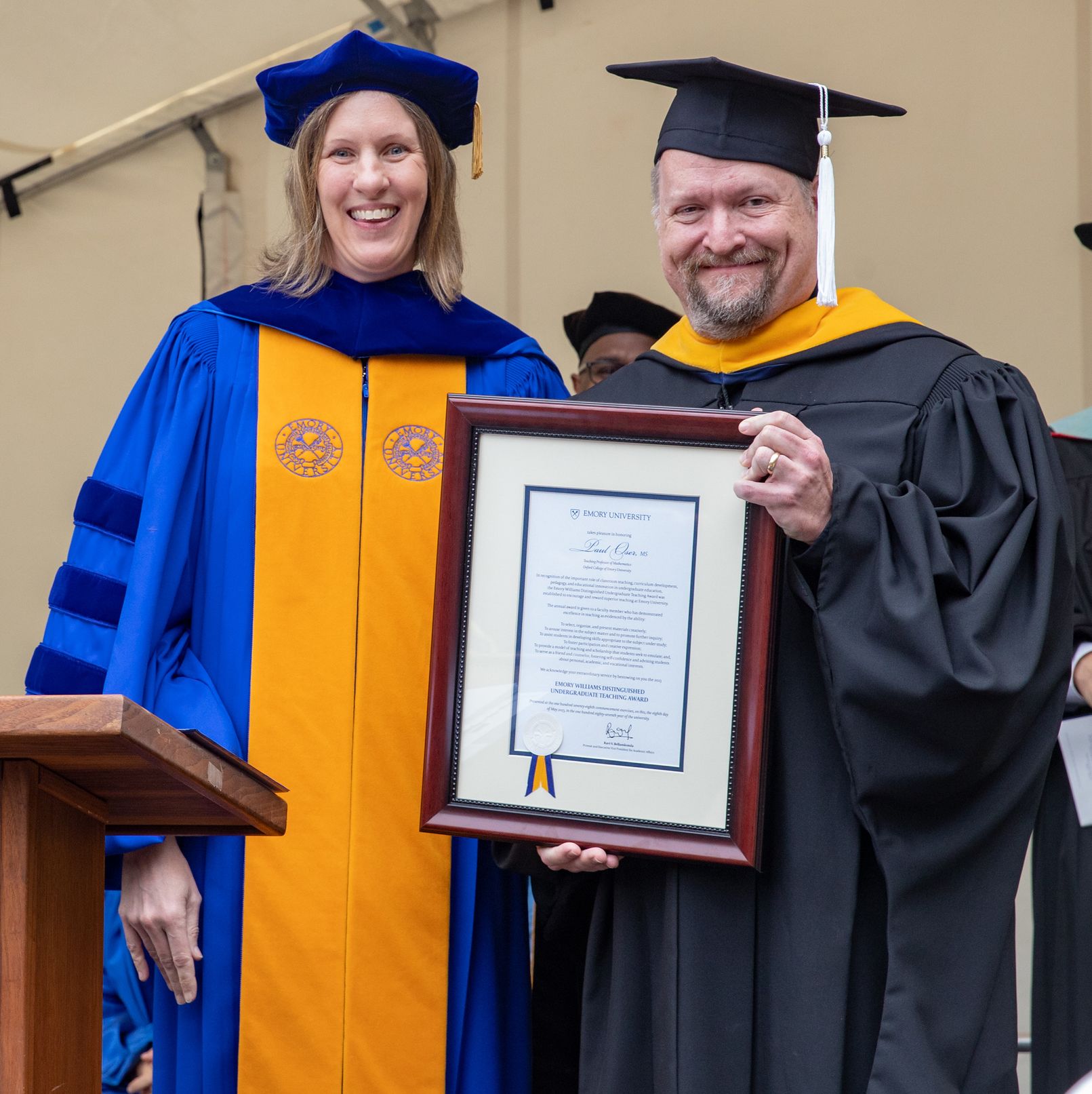 Dr. Paul Oser with Dr. Kristin Bonnie receiving Distinguished Teaching Award.