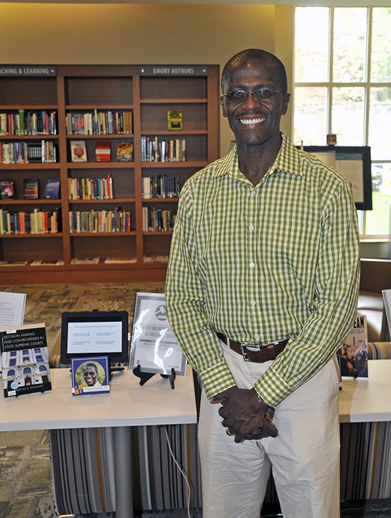 Salmon Shomade, Visiting Associate Professor of Political Science, with his book and conference paper.