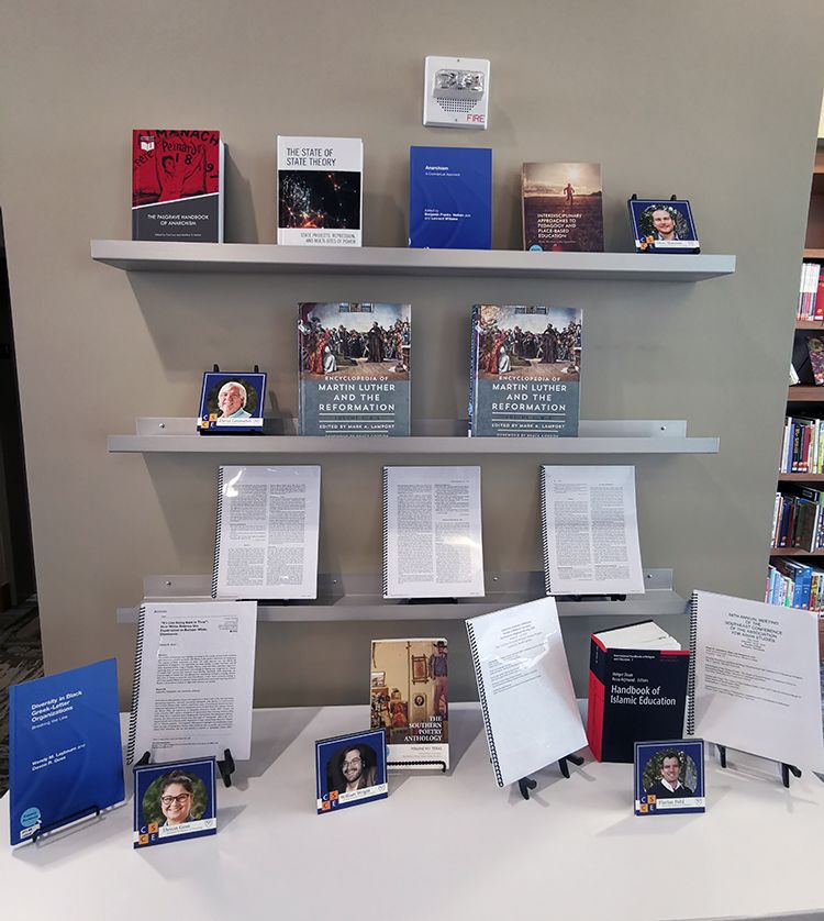 Faculty books and presentations line the walls of the Oxford library.