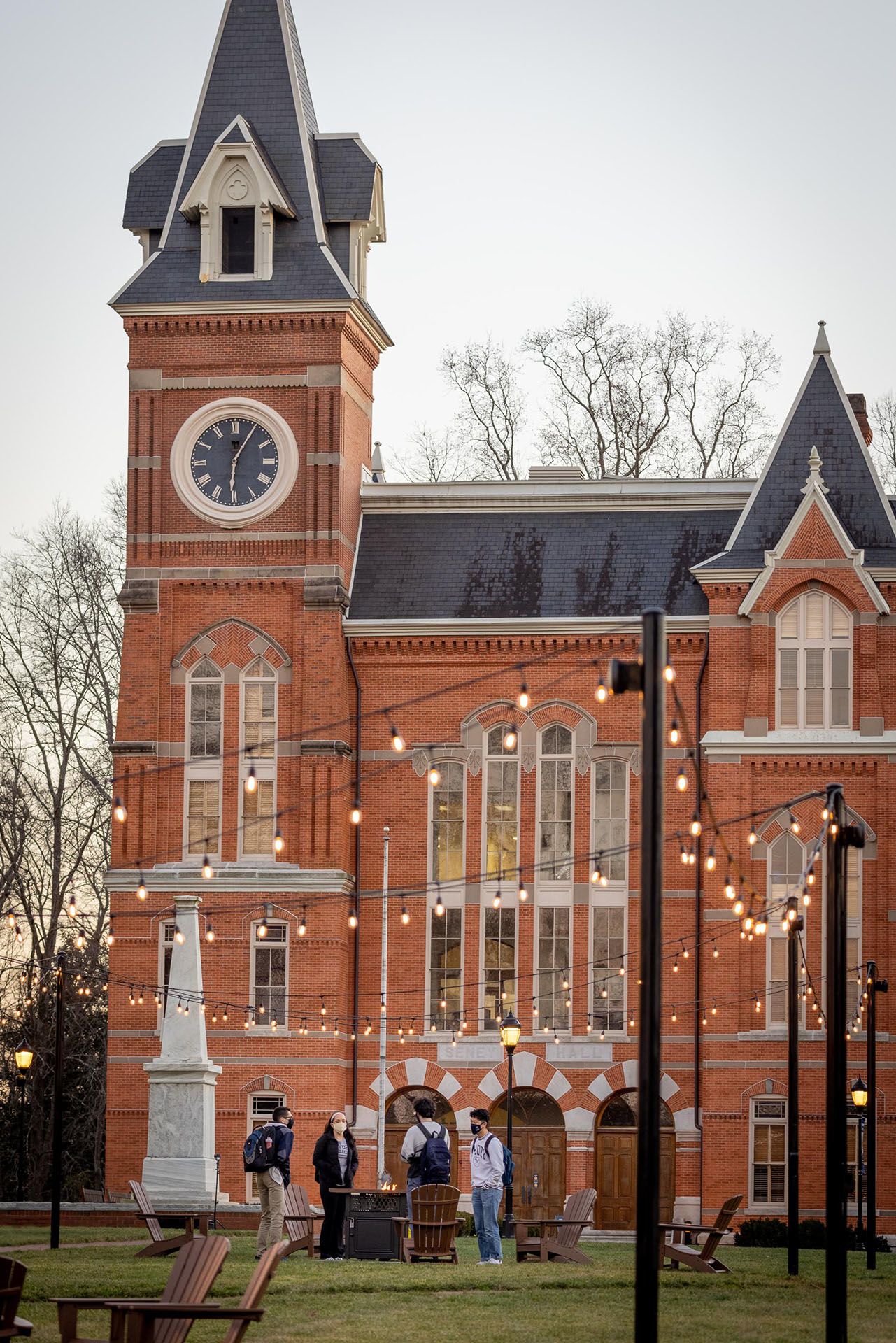 Students gather under string lights in front of Seney Hall.