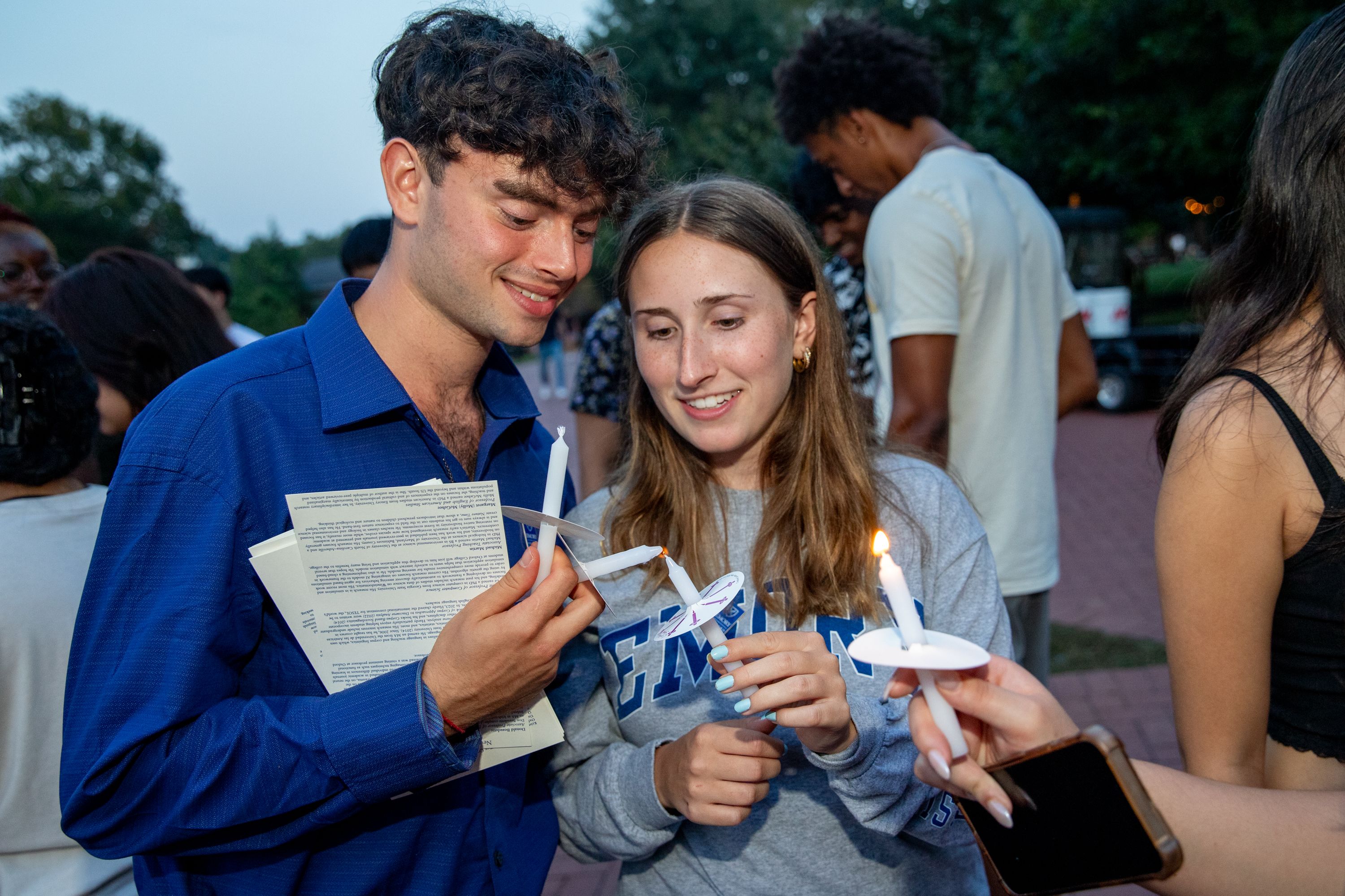 Students lighting their candles during the Candlelight Procession ceremony.
